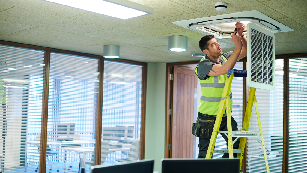 Air Con HVAC engineer repairing a unit in an office