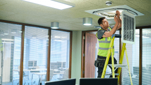 Air Con HVAC engineer repairing a unit in an office